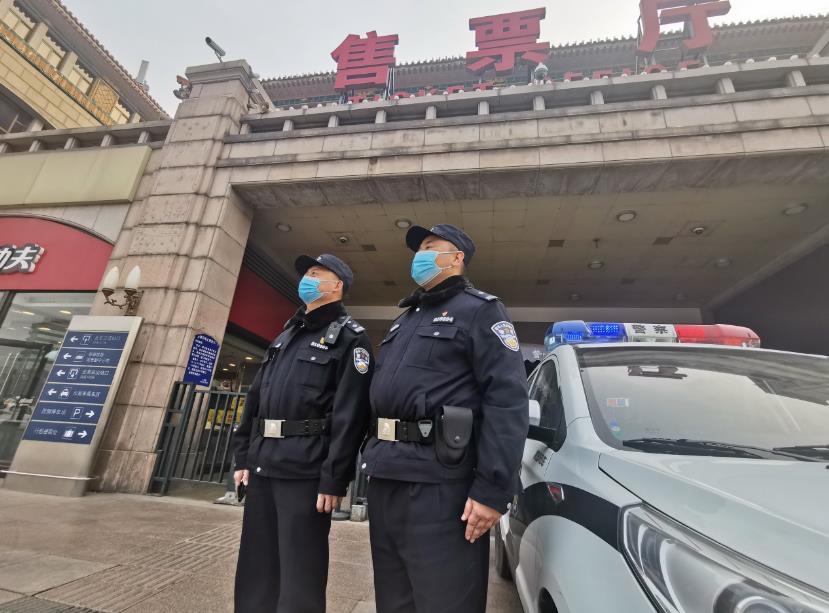 The picture shows the police on duty in front of the ticket office of Beijing Railway Station.